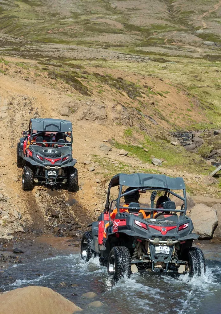 Two buggies driving through a stream