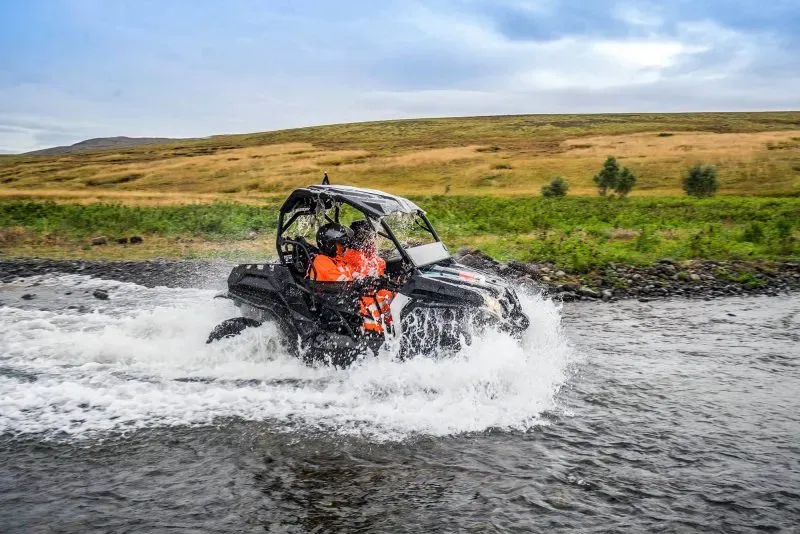 Buggy crossing a river with water spraying around it