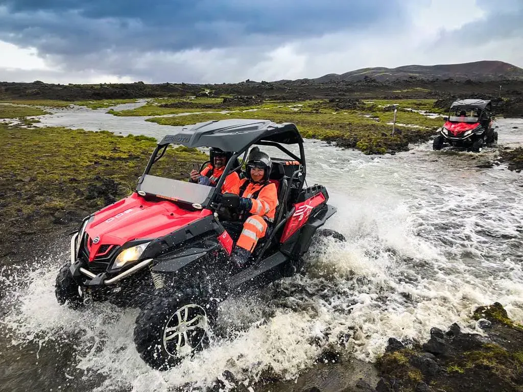 Red buggy splashing through a river